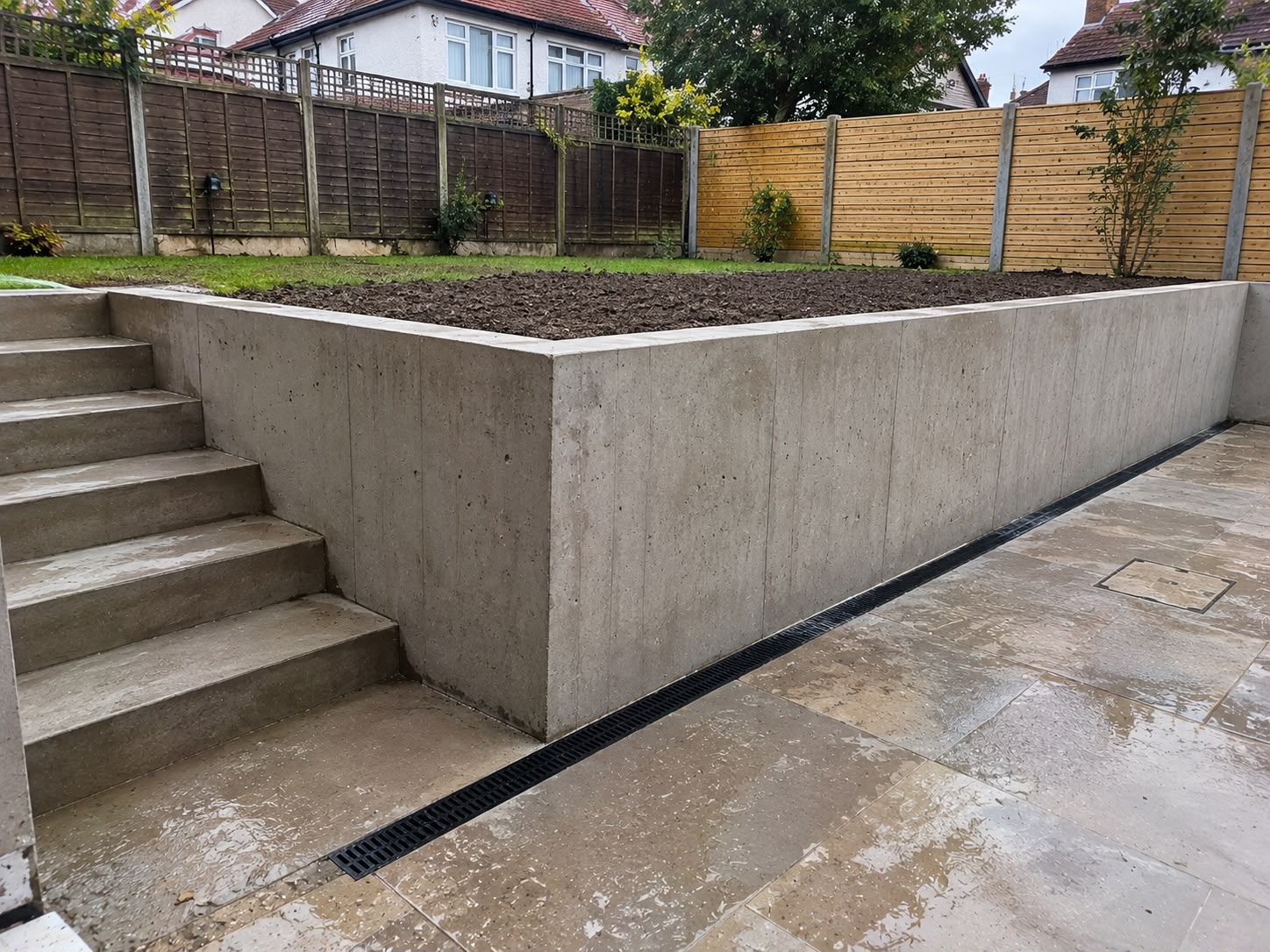 Concrete retaining wall installation for a sloped residential garden in Enfield